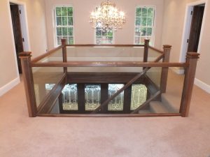 walnut staircase with glass and chandelier