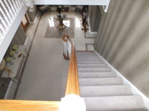 white staircase, oak handrail and bottom step, volute