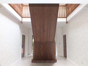 twin curved walnut staircase, under paneling, walnut doors