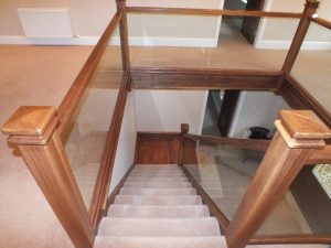 walnut staircase with glass and carpet, newel capping
