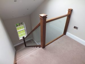 walnut staircase with glass and carpet