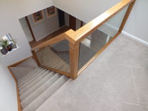oak staircase with glass and carpet