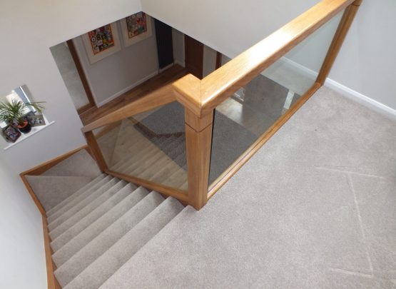 oak staircase with glass and carpet